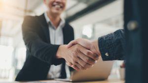 young businessman shaking hands with a business woman during a meeting in the office, 